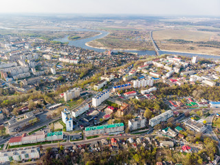 Fototapeta premium Panorama of a small town, river, forest, fields, road, bridge and sky. The photo was taken by a quadcopter, drone. Summer and spring. Skyview. Top view. Travel and tourism. Created by DGJ drone.
