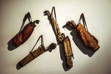 Set of old vintage golf clubs in bag hanging on the wall