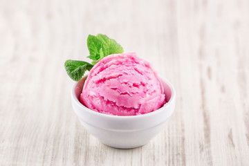 strawberry ice cream with bowl on wooden background