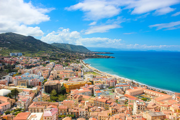 Amazing seascape of Sicilian Cefalu in Italy taken from adjacent hills overlooking the bay. The beautiful city on Tyrrhenian coast is popular summer holiday spot. Taken on sunny day with light clouds