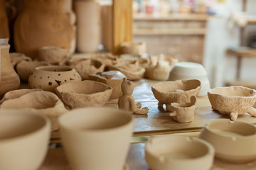 Bunch of fresh unprocessed clay pots placed on a working surface