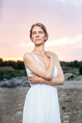 Fototapeta na wymiar woman in white dress on the background of blue sky