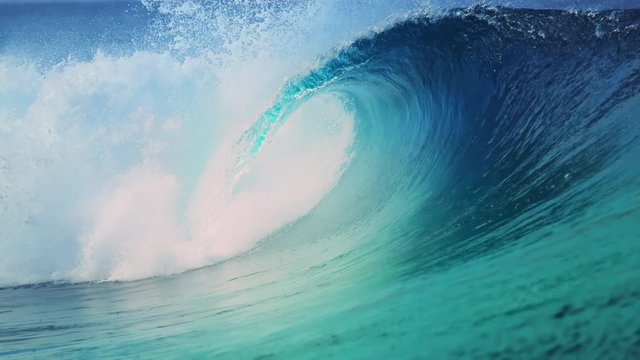 SLOW MOTION, CLOSE UP: Stunning glassy tube wave splashes wildly as it approaches the sunny beach in Teahupoo, Tahiti. Beautiful wave glimmers in the bright summer sunshine near remote tropical island