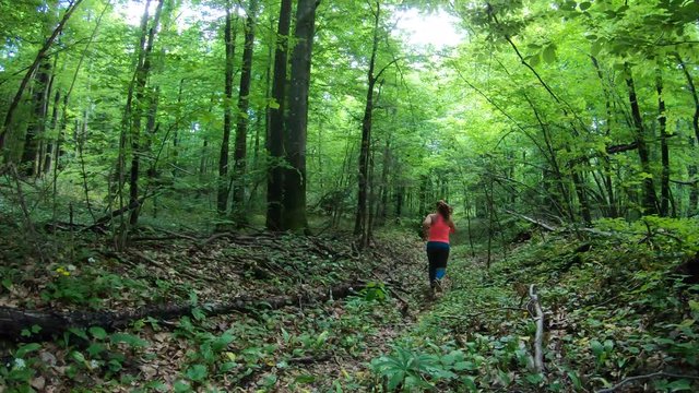 Overweight woman running in the forest