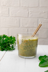 Matcha, spinach, cilantro smoothie on white wooden background, copy space.