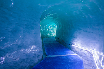 Bright lights illuminate the blue corridor carved into the ice of Mer De Glace.