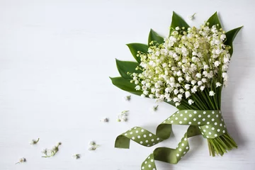Foto op Canvas Bouquet flowers of lily of the valley on a white wooden background © tachinskamarina