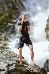 Muay thai fighter training by the waterfall