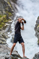 Muay thai fighter training by the waterfall