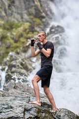 Muay thai fighter training by the waterfall