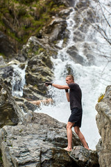 Obraz premium Muay thai fighter training by the waterfall