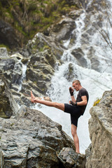 Muay thai fighter training by the waterfall