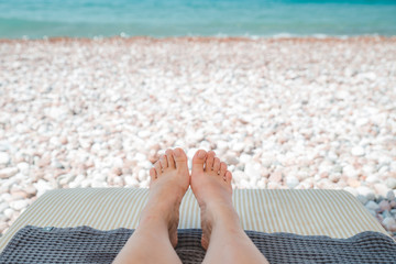 woman feet on front of sea rocky beach. summer time