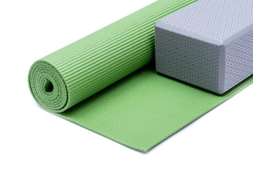 Grey Yoga Block on Green Yoga Mat isolated on white background.