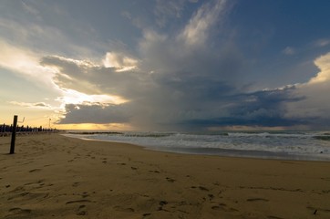 Fototapeta na wymiar Seascape with beach, rocks and cloudy sky