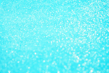 Blurred bokeh light blue background, Christmas and New Year holidays background. Party concept. Festive holiday card bright backdrop. Defocused. Flat lay, top view, copy space.