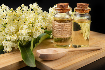 Beautiful flowers of elderberry and medicinal juice in a bottle. Natural home remedies for colds.