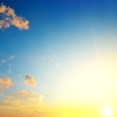 Scenic sunset with sun rays against bright blue sky