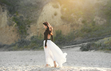 Ballet woman Dancer at Sunset beach. Classical dance in white chiffon skirt
