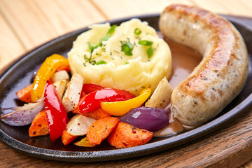 sausage with mashed potato and vegetables, wooden background