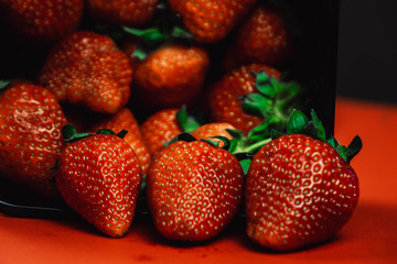 Fresh juicy strawberries with leaves. Strawberry on a red background