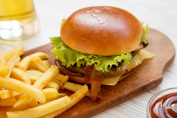 Hamburger with lettuce, cheese and bacon, side view. Closeup.