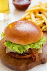 Hamburger with lettuce, cheese and bacon, side view. Close-up.