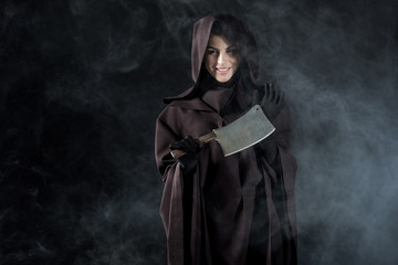 woman in death costume holding cleaver in smoke on black