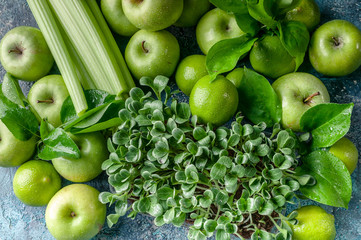 Detox Texture: milk thistle microgreen and green fruit on a concrete background.