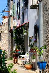 Fototapeta na wymiar Colorful narrow street in Sibenik, Croatia. Sibenik is popular summer travel destination.
