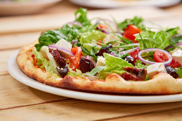 vegetarian pizza with fresh tomatoes, olives, tofu and red onion