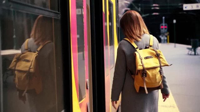 single woman traveling by train with backpack on the search of adventure. Public transport as a great way to get to know an european city. Female tourist traveling trough the world
