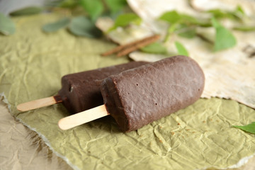 two ice cream in chocolate glaze on a stick, on craft paper