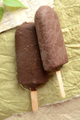 two ice cream in chocolate glaze on a stick, on craft paper
