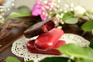 fruit ice cream on a stick, on a background of green leaves