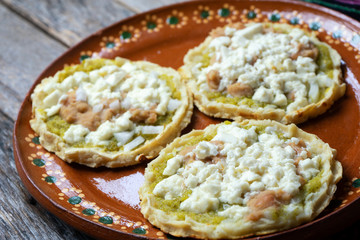 Mexican food: sopes with green sauce and beans