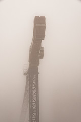 silhouette of an industrial crane immersed in the morning fog