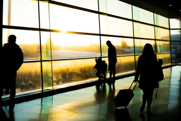 Naklejka premium Airport, silhouette of father with kids and passengers, Dublin Ireland, sunrise
