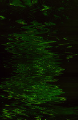 Abstract dark green paint background. Smooth glossy liquid fluid surface. Water expanse. Ripples effect pattern texture.