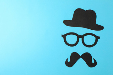 Decorative glasses, mustache and hat on color background, space for text