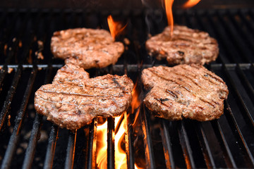 Grilling burgers on a barbecue with flames
