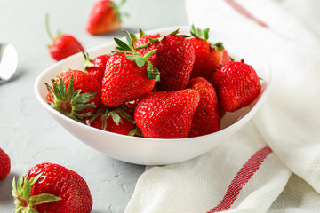 Plate with fresh strawberries, spoon and kitchen towel on white background, closeup and space for text