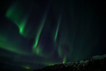 Aurora Borealis behind a snowy mountain