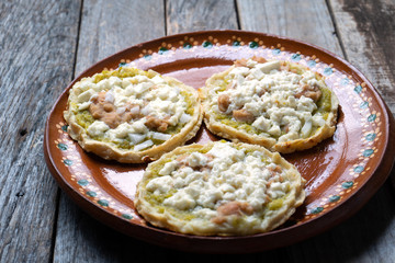 Mexican food: sopes with green sauce and beans