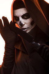 woman with skull makeup holding knife isolated on white