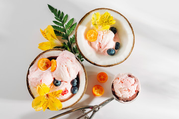 Balls of ice cream decoration flowers in halves of coconut. Summer tropical concept.