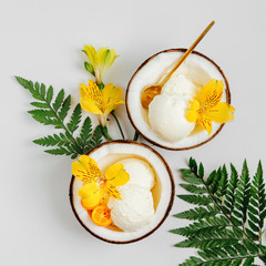 Balls of ice cream decoration flowers in halves of coconut. Summer tropical concept.