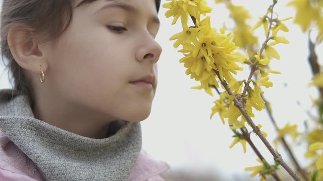 Seasonal allergies. A young girl smells flowers and begins to choke. Allergy to pollen.