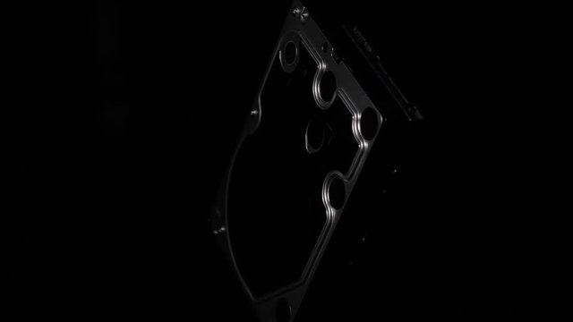 Close up hard disk drive spinning in space isolated on black background