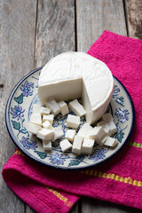 Fresh and tasty mexican panela cheese on wood background